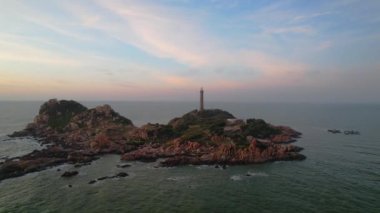 Güneşin doğuşunda antik deniz feneriyle küçük bir adanın manzarası güzel ve huzurludur. Bu sadece Vietnam 'daki bir adada bulunan eski bir deniz feneri.
