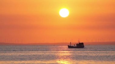 Sunset landscape when fishing boat out to sea to harvest fish end the day.