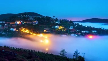 Time lapse night and dawn scene hillside a small town in fog shrouded by colorful houses in highlands of Da Lat, Vietnam so beautiful