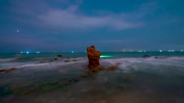 Time lapse rocky beach and green moss in night and sunrise sky at a beautiful beach in central Vietnam