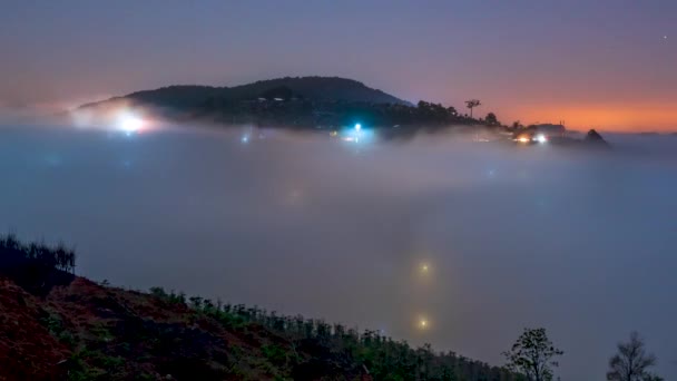 時間経過夜と夜明けのシーンの丘の中腹に霧の中で小さな町ダラット ベトナムの高地にカラフルな家に囲まれてとても美しい — ストック動画