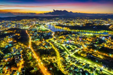 Da Lat şehrinin hava görüntüsü gece batımı güzel turizm merkezi dağlık Vietnam 'da. Kentsel gelişim dokusu, yeşil parklar ve şehir gölü.