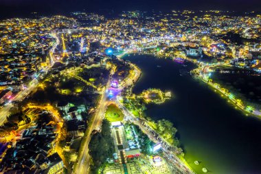 Aerial view of Da Lat city night beautiful tourism destination in central highlands Vietnam. Urban development texture, green parks and city lake.