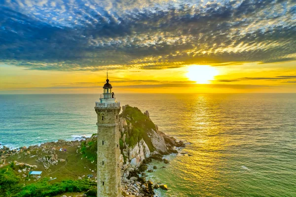 stock image Landscape of small island with ancient lighthouse at sunrise sky is beautiful and peaceful. This is only ancient lighthouse is located on island in Vietnam