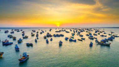 Aerial view of Mui Ne fishing village in sunset sky with hundreds of boats anchored to avoid storms, this is a beautiful bay in central Vietnam clipart