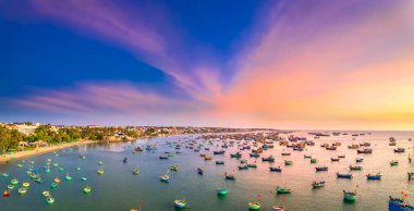 Güneş batımında Mui Ne 'nin hava manzaralı balıkçı köyü. Fırtınalardan korunmak için yüzlerce tekne demirli. Burası Vietnam' ın merkezinde güzel bir koy.