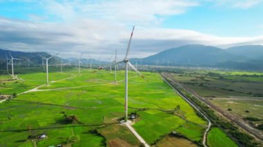 Rüzgâr çiftliği ya da rüzgar parkının panoramik görüntüsü. Rüzgar türbinleri elektrik üreten yeşil çayır. Yeşil enerji kavramı.