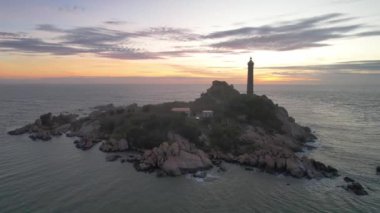 Güneşin doğuşunda antik deniz feneriyle küçük bir adanın havadan görünüşü güzel ve huzur vericidir. Bu sadece Vietnam 'daki bir adada bulunan eski bir deniz feneri.