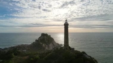 Güneşin doğuşunda antik deniz feneriyle küçük bir adanın havadan görünüşü güzel ve huzur vericidir. Bu sadece Vietnam 'daki bir adada bulunan eski bir deniz feneri.