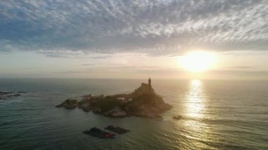 Güneşin doğuşunda antik deniz feneriyle küçük bir adanın havadan görünüşü güzel ve huzur vericidir. Bu sadece Vietnam 'daki bir adada bulunan eski bir deniz feneri.