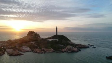 Güneşin doğuşunda antik deniz feneriyle küçük bir adanın havadan görünüşü güzel ve huzur vericidir. Bu sadece Vietnam 'daki bir adada bulunan eski bir deniz feneri.