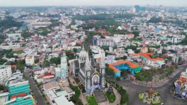 Thu Dau Mot şehrinin sabah havadan görünüşü ve merkezde kilise var. Kentsel kalkınma dokusu, taşımacılık altyapısı ve Güneydoğu Vietnam bölgesinde Be Nehri boyunca yeşil parklar