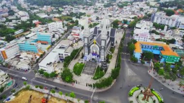 Thu Dau Mot şehrinin sabah havadan görünüşü ve merkezde kilise var. Kentsel kalkınma dokusu, taşımacılık altyapısı ve Güneydoğu Vietnam bölgesinde Be Nehri boyunca yeşil parklar