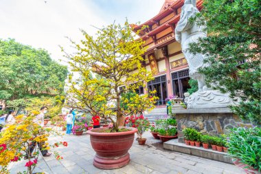 Ho Chi Minh Şehri, Vietnam - 22 Ocak 2023: Ho Chi Minh Şehri, Vietnam 'da yeni yıl kutlamalarında barış için hacılarla birlikte dua etmek üzere tapınakta canlı bir bahar havası var