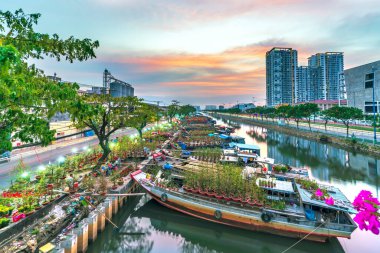 Ho Chi Minh City, Vietnam - 18 Ocak 2023: kanal iskelesi boyunca pazarda çiçek teknesi. Çiftçiler, Ho Chi Minh, Vietnam 'daki Ay Yeni Yılı' nda kayısı çiçeği ve diğer çiçekleri satıyor.