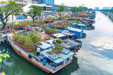 Ho Chi Minh City, Vietnam - 18 Ocak 2023: kanal iskelesi boyunca pazarda çiçek teknesi. Çiftçiler, Ho Chi Minh, Vietnam 'daki Ay Yeni Yılı' nda kayısı çiçeği ve diğer çiçekleri satıyor.