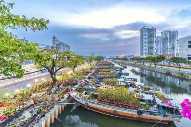 Ho Chi Minh City, Vietnam - 18 Ocak 2023: kanal iskelesi boyunca pazarda çiçek teknesi. Çiftçiler, Ho Chi Minh, Vietnam 'daki Ay Yeni Yılı' nda kayısı çiçeği ve diğer çiçekleri satıyor.