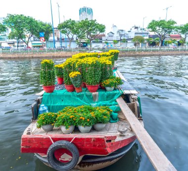 Ho Chi Minh City, Vietnam - 18 Ocak 2023: kanal iskelesi boyunca pazarda çiçek teknesi. Çiftçiler, Ho Chi Minh, Vietnam 'daki Ay Yeni Yılı' nda kayısı çiçeği ve diğer çiçekleri satıyor.