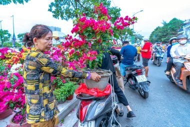Ho Chi Minh Şehri, Vietnam - 18 Ocak 2023: Çiçekçiden çiçek alma telaşı, yerel halk dekorasyon amacıyla çiçek satın alıyor..