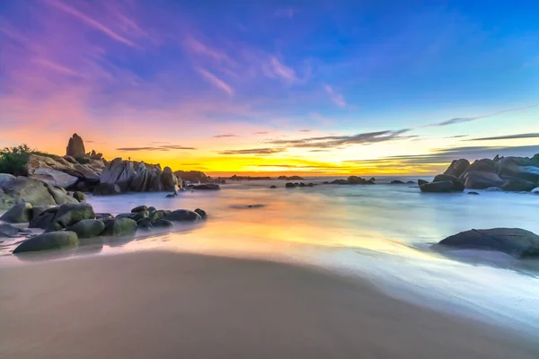 stock image Dawn on the beach brightly colored clouds, beneath a rock with beautiful shapes create beautiful scenery welcome bright day fresh