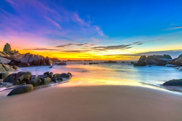 Úsvit Pláži Jasně Barevné Mraky Pod Skálou Krásnými Tvary Vytvořit — Stock fotografie