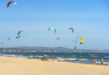 Mui Ne, Vietnam - 11 Şubat 2023: uçurtma sörfü. Mui Ne Körfezi 'nde birçok uçurtma silueti var ve her türlü gösteriyi yapıyorlar. Spor, sağlık, eğlence kavramı. Doğada tatiller