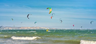 Mui Ne, Vietnam - 11 Şubat 2023: uçurtma sörfü. Mui Ne Körfezi 'nde birçok uçurtma silueti var ve her türlü gösteriyi yapıyorlar. Spor, sağlık, eğlence kavramı. Doğada tatiller