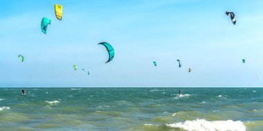 Mui Ne, Vietnam - 11 Şubat 2023: uçurtma sörfü. Mui Ne Körfezi 'nde birçok uçurtma silueti var ve her türlü gösteriyi yapıyorlar. Spor, sağlık, eğlence kavramı. Doğada tatiller
