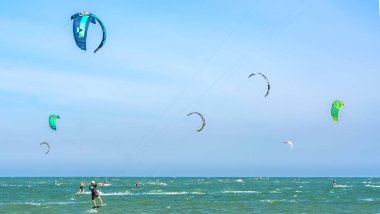 Mui Ne, Vietnam - 11 Şubat 2023: uçurtma sörfü. Mui Ne Körfezi 'nde birçok uçurtma silueti var ve her türlü gösteriyi yapıyorlar. Spor, sağlık, eğlence kavramı. Doğada tatiller