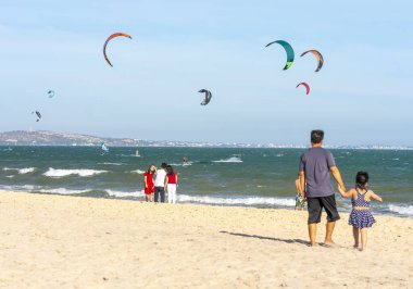 Mui Ne, Vietnam - 11 Şubat 2023: uçurtma sörfü. Mui Ne Körfezi 'nde birçok uçurtma silueti var ve her türlü gösteriyi yapıyorlar. Spor, sağlık, eğlence kavramı. Doğada tatiller