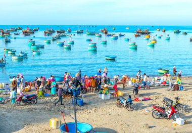 Phan Thiet, Vietnam - 12 Şubat 2023: Balık pazarı deniz manzarası insanlar sepette balık satışı için toplandı, kürek çeken balıkçılar Phan Thiet, Vietnam 'da bir balıkçı köyü getirdiler