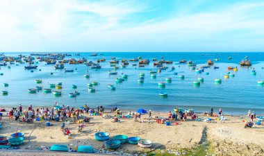 Phan Thiet, Vietnam - 12 Şubat 2023: Balık pazarı deniz manzarası insanlar sepette balık satışı için toplandı, kürek çeken balıkçılar Phan Thiet, Vietnam 'da bir balıkçı köyü getirdiler