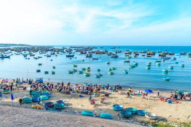 Phan Thiet, Vietnam - 12 Şubat 2023: Balık pazarı deniz manzarası insanlar sepette balık satışı için toplandı, kürek çeken balıkçılar Phan Thiet, Vietnam 'da bir balıkçı köyü getirdiler