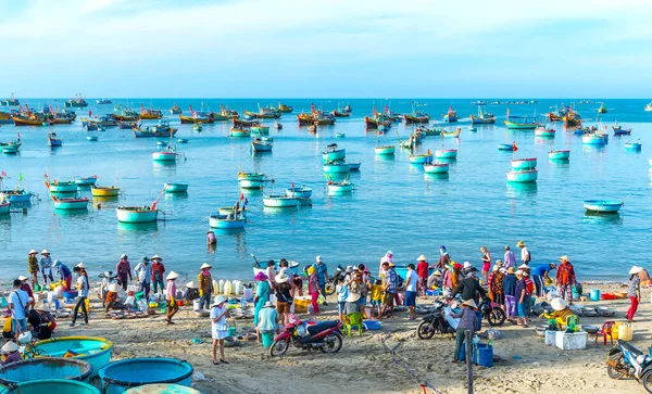 Phan Thiet, Vietnam - 12 Şubat 2023: Balık pazarı deniz manzarası insanlar sepette balık satışı için toplandı, kürek çeken balıkçılar Phan Thiet, Vietnam 'da bir balıkçı köyü getirdiler