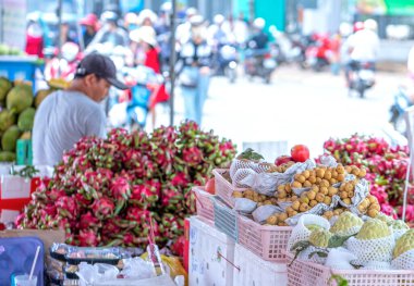 Ho Chi Minh Şehri, Vietnam - 18 Haziran 2023: Sabahın erken saatlerinde, renkli meyve sepetleri açık hava pazarında kalabalık ve kalabalık caddelerde görüldü