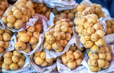 Langsat meyvesi pazarda satılıyor. Tatlı ve ekşi meyve, bol besin ve sağlık için iyi.