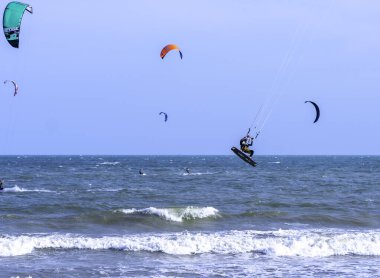 Mui Ne, Vietnam - 29 Kasım 2023: uçurtma sörfü. Mui Ne Körfezi 'nde birçok uçurtma silueti var ve her türlü gösteriyi yapıyorlar. Spor, sağlık, eğlence kavramı. Doğada tatiller