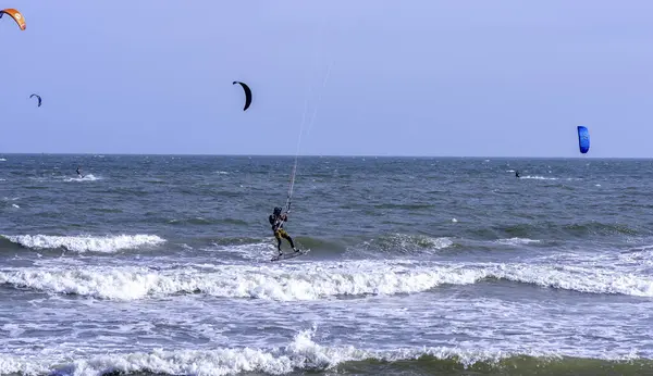 Mui Ne, Vietnam - 29 Kasım 2023: uçurtma sörfü. Mui Ne Körfezi 'nde birçok uçurtma silueti var ve her türlü gösteriyi yapıyorlar. Spor, sağlık, eğlence kavramı. Doğada tatiller