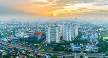 Ho Chi Minh şehri, Vietnam - 13 Kasım 2023: Güney Vietnam 'da güneş doğarken Saigon şehrinin hava manzarası. Ho Chi Minh şehrindeki kentsel gelişim dokusu, ulaşım altyapısı ve yeşil parklar, Vietnam