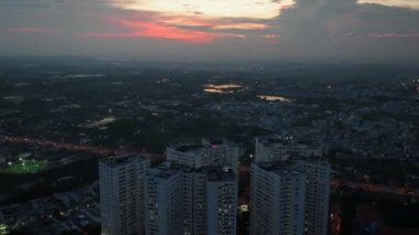 Güney Vietnam 'da günbatımında gökyüzü olan Saigon şehir manzarasının hava görüntüsü. Kentsel kalkınma dokusu, ulaşım altyapısı ve yeşil parklar