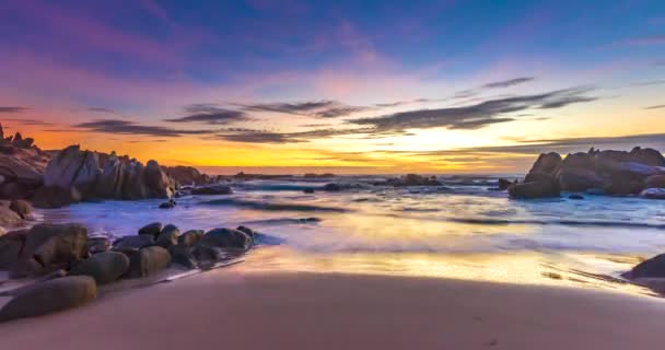 ビーチで明るく彩られた雲の夜明けの時間は 美しい形の岩の下で 美しい景色を歓迎する明るい日を新鮮に作り出します — ストック動画