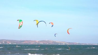 Mui Ne, Vietnam - 11 Şubat 2023: uçurtma sörfü. Mui Ne Körfezi 'nde birçok uçurtma silueti var ve her türlü gösteriyi yapıyorlar. Spor, sağlık, eğlence kavramı. Doğada tatiller