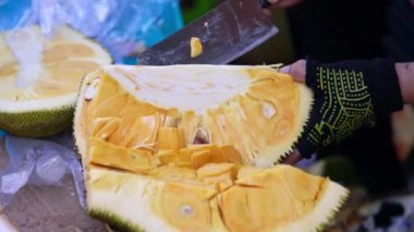 Bir kadının eli pazarda Jackfruit 'i kesiyor, Vietnam meyveleri, tatlı ve besleyici meyveler.