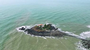 Vung Tau şehrindeki Hon Ba adasının havadan görünüşü, Vietnam. Dolunay takviminde, gelgit çekildiğinde insanlar dağdaki tapınağı ziyaret etmek için adanın bir ucundan diğer ucuna yürüyebilirler. Ruhani seyahat konsepti.