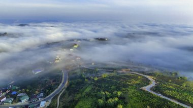 Sabah Da Lat kenti yakınlarındaki Cau Dat banliyösünün havadan görünüşü ve Vietnam dağlarında sisli bir gökyüzü. Kentsel kalkınma yapısı, ulaştırma altyapısı, tarımda sera