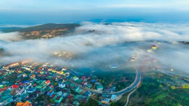 Sabah Da Lat kenti yakınlarındaki Cau Dat banliyösünün havadan görünüşü ve Vietnam dağlarında sisli bir gökyüzü. Kentsel kalkınma yapısı, ulaştırma altyapısı, tarımda sera