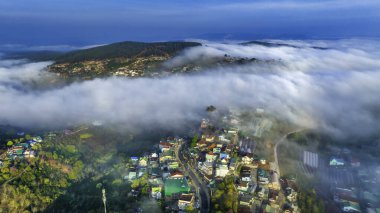Sabah Da Lat kenti yakınlarındaki Cau Dat banliyösünün havadan görünüşü ve Vietnam dağlarında sisli bir gökyüzü. Kentsel kalkınma yapısı, ulaştırma altyapısı, tarımda sera