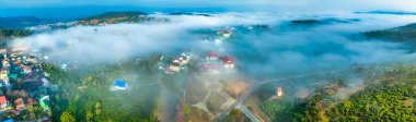 Sabah Da Lat kenti yakınlarındaki Cau Dat banliyösünün havadan görünüşü ve Vietnam dağlarında sisli bir gökyüzü. Kentsel kalkınma yapısı, ulaştırma altyapısı, tarımda sera