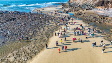 Vung Tau şehrindeki Hon Ba adasının havadan görünüşü, Vietnam. Dolunay takviminde, gelgit çekildiğinde insanlar dağdaki tapınağı ziyaret etmek için adanın bir ucundan diğer ucuna yürüyebilirler. Ruhani seyahat konsepti.