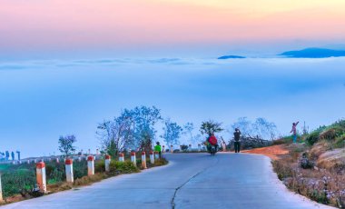 Da Lat, Vietnam - 21 Şubat 2024: Vietnam 'ın Da Lat kentindeki çiğ kaplı tepeleri ve dağları hayranlıkla seyreden birçok turist ve motorsikletle sabah platoda trafiği geçmek